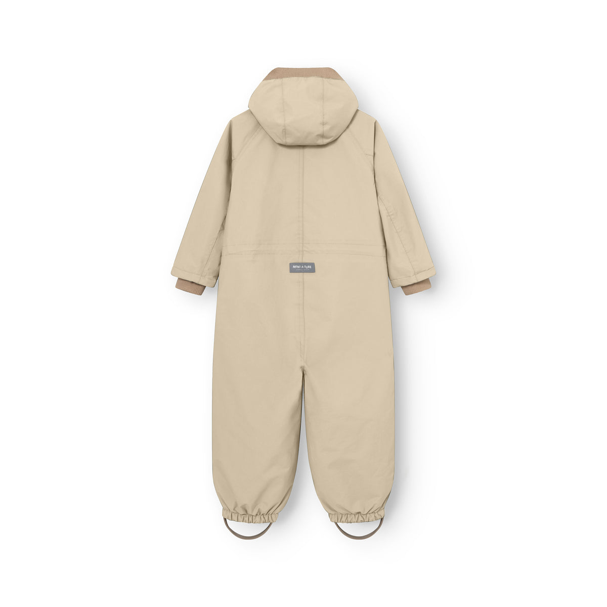 MATWISTO all season heldragt i farven Sesame, set bagfra på hvid baggrund. Den har aftagelig hætte, ribkanter ved ærmerne, MINI A TURE-mærke på ryggen og elastiske bukseben med fodstropper.