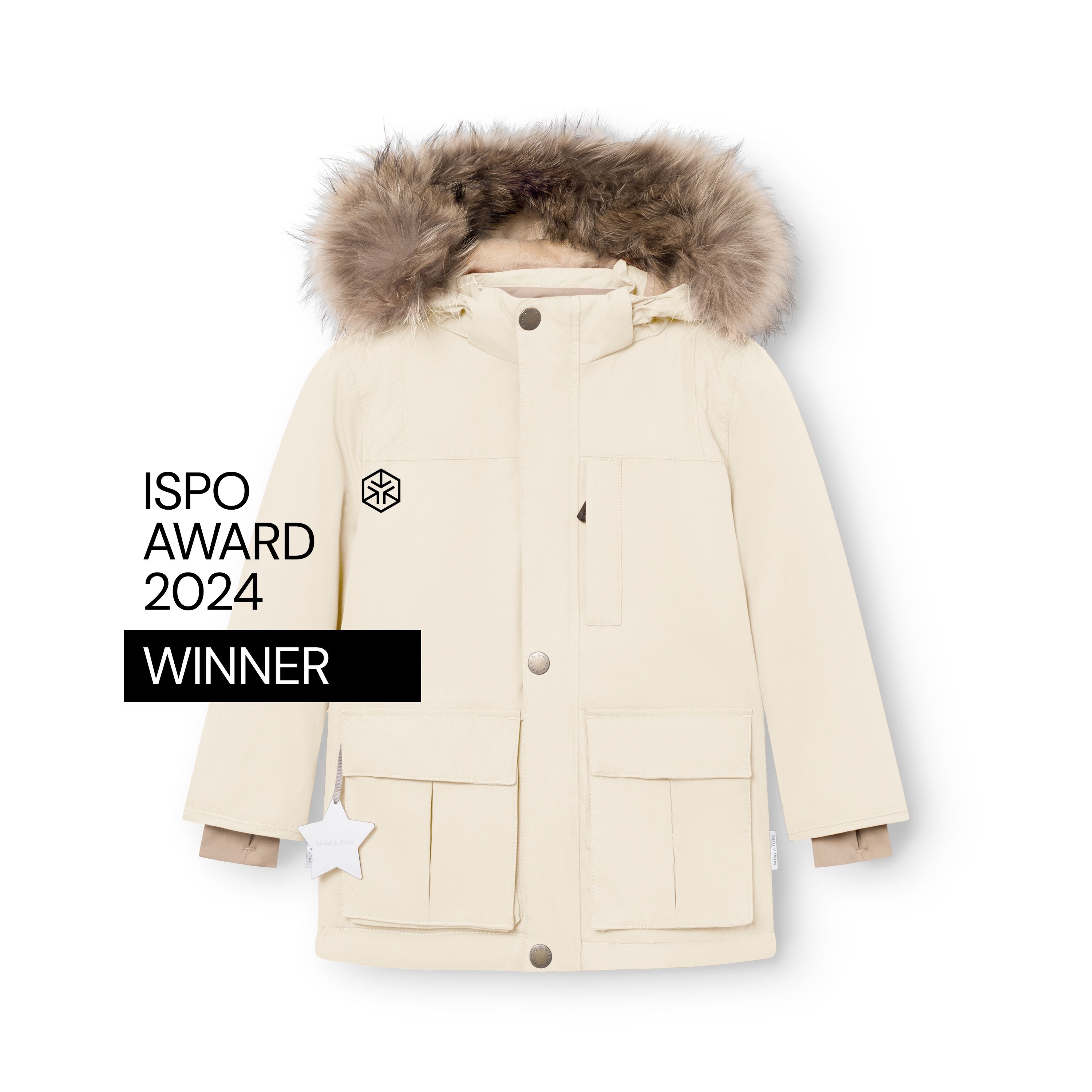 MATKASTORIO fleeceforet vinterjakke i cremefarve, fotograferet forfra på hvid baggrund med ISPO Award 2024 Winner-mærket synligt. Jakken er lukket med trykknapper, har fire store frontlommer med klaplåg, en hvid refleksstjerne, der hænger fra venstre lomme, beige snemanchetter ved ærmerne og en opslået hætte med bred, naturlig ægte pelskant.
