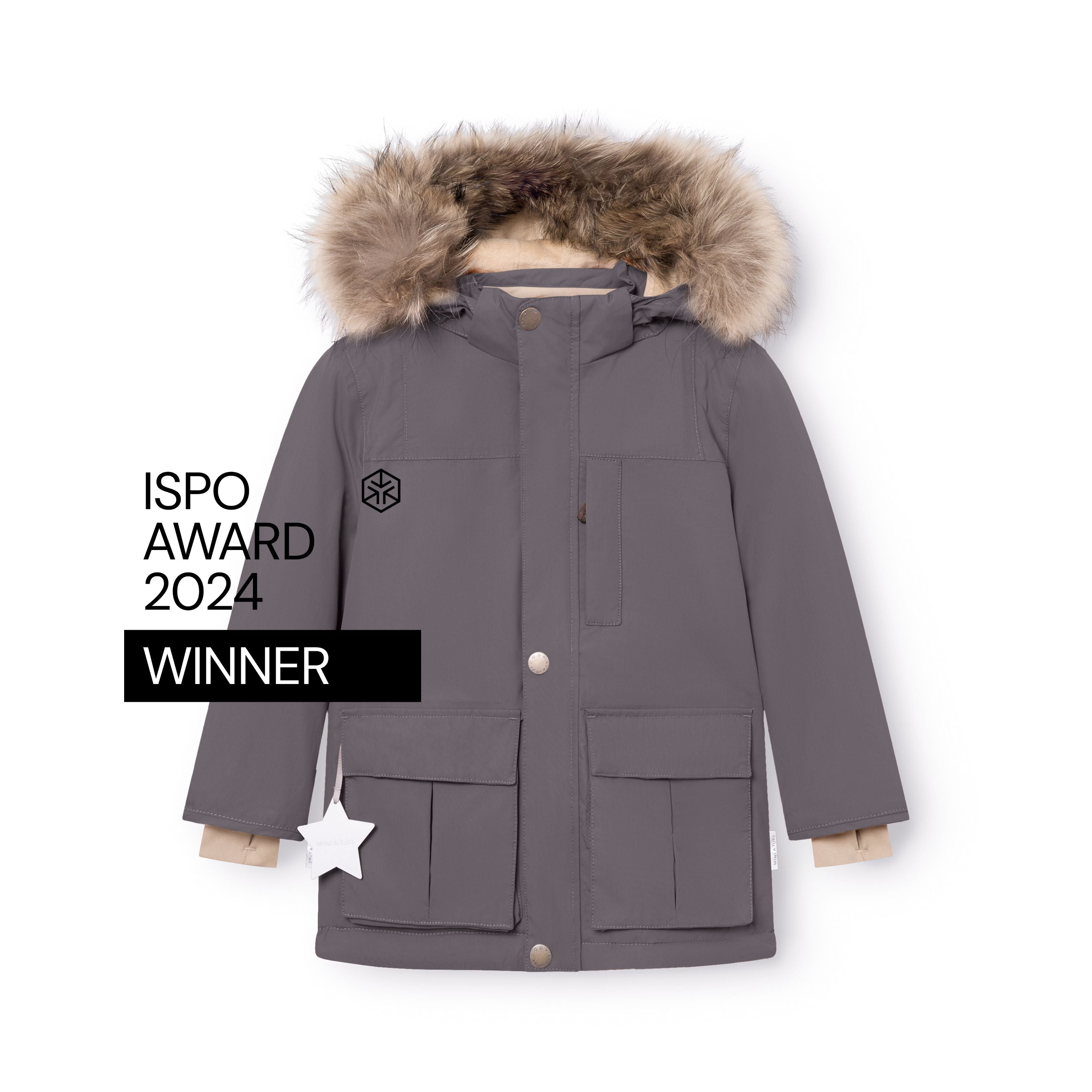 MATKASTORIO fleeceforet vinterjakke i grålilla, fotograferet forfra på hvid baggrund med ISPO Award 2024 Winner-mærket synligt. Jakken har fire frontlommer med magnetlukning, beige snemanchetter ved håndleddene, en hvid refleksstjerne på venstre lomme og en stor, aftagelig hætte med bred ægte pelskant – alt tydeligt fremhævet.