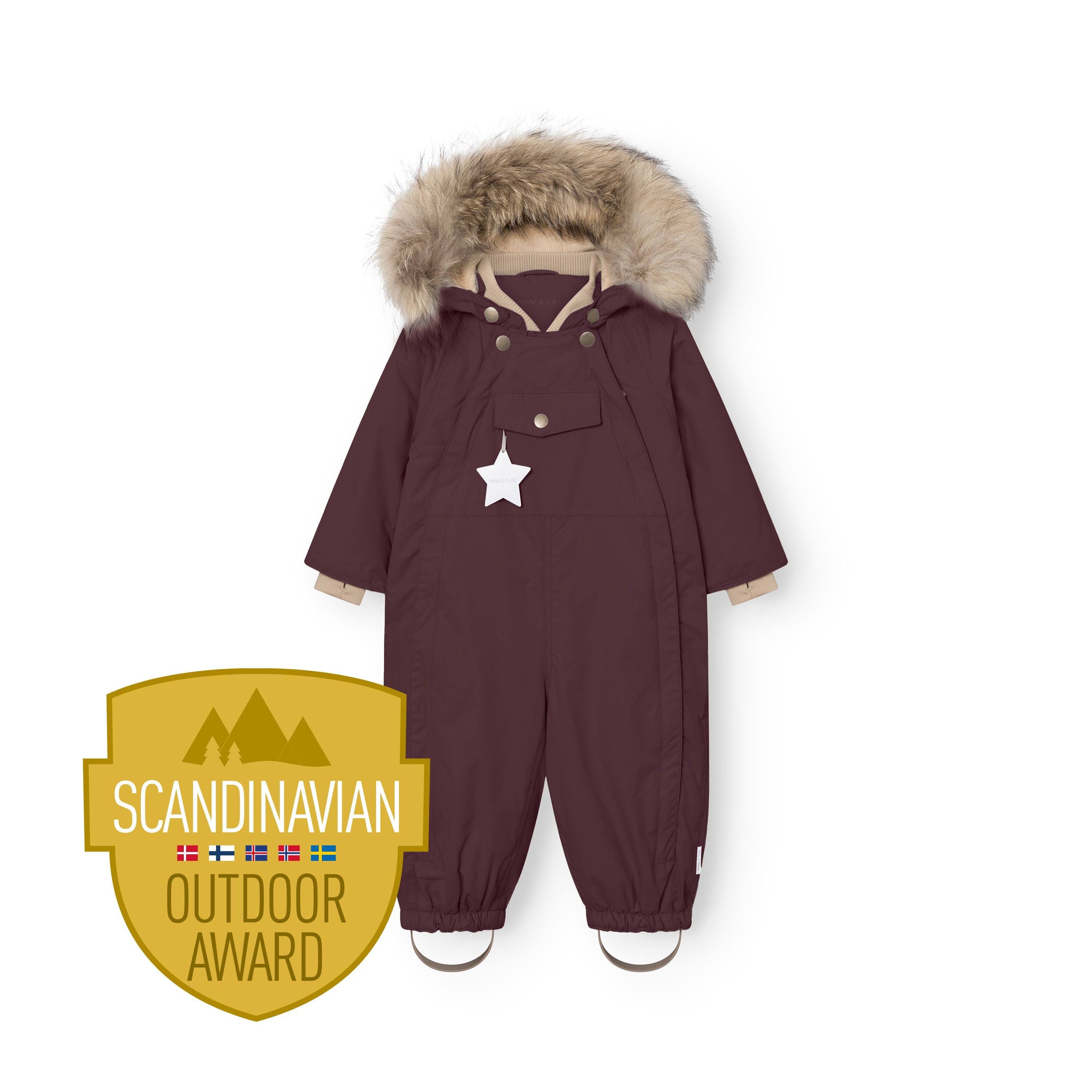 MATWISTI fleeceforet flyverdragt med pels i mørk bordeaux, fotograferet forfra i fuld længde med hætten oppe og den store, naturlige pelskant udfoldet. Den hvide stjernerefleks hænger fra brystlommen, beige manchetter ses ved håndleddene, og de rynkede bukseben med beige fodstropper er synlige ved anklerne. Scandinavian Outdoor Award-logoet er placeret i nederste venstre hjørne.
