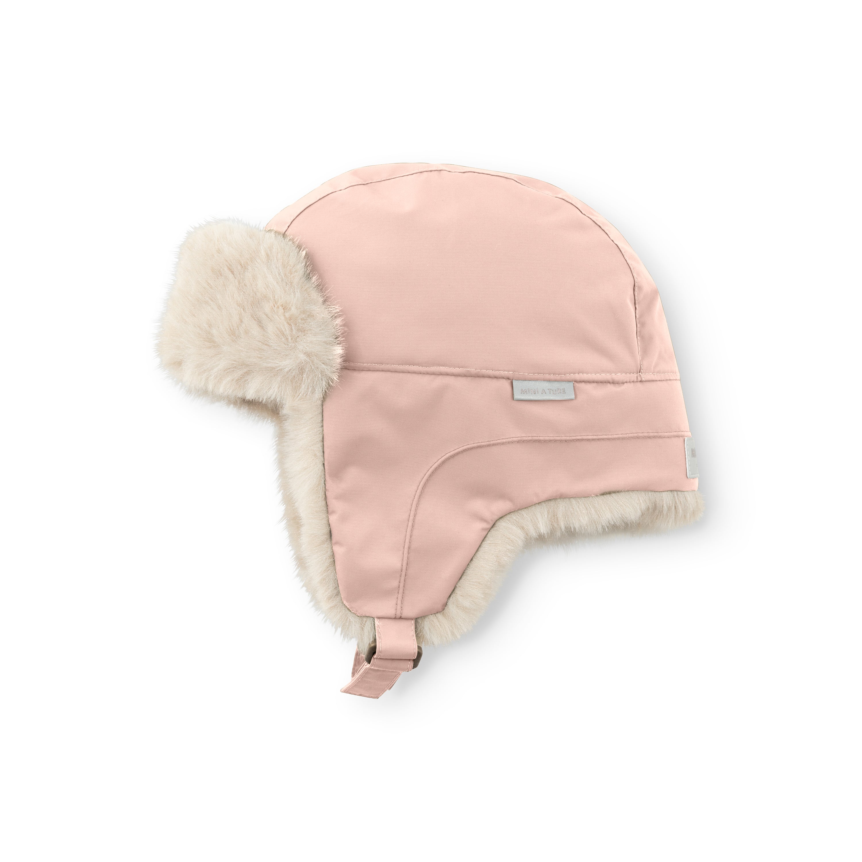 MATCRISTER teddyforet vinterhue i dæmpet rosa set fra en skrå vinkel. Den har blødt, cremefarvet teddyfleece langs øreklapperne og en matchende rosa velcrostrop, der hænger ned i siden mod en hvid baggrund.